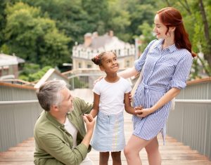 Weekend with child. Couple of businessmen feeling happy spending weekend with adopted child