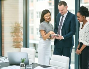 Cropped shot of three businesspeople looking over a tablet in the office.